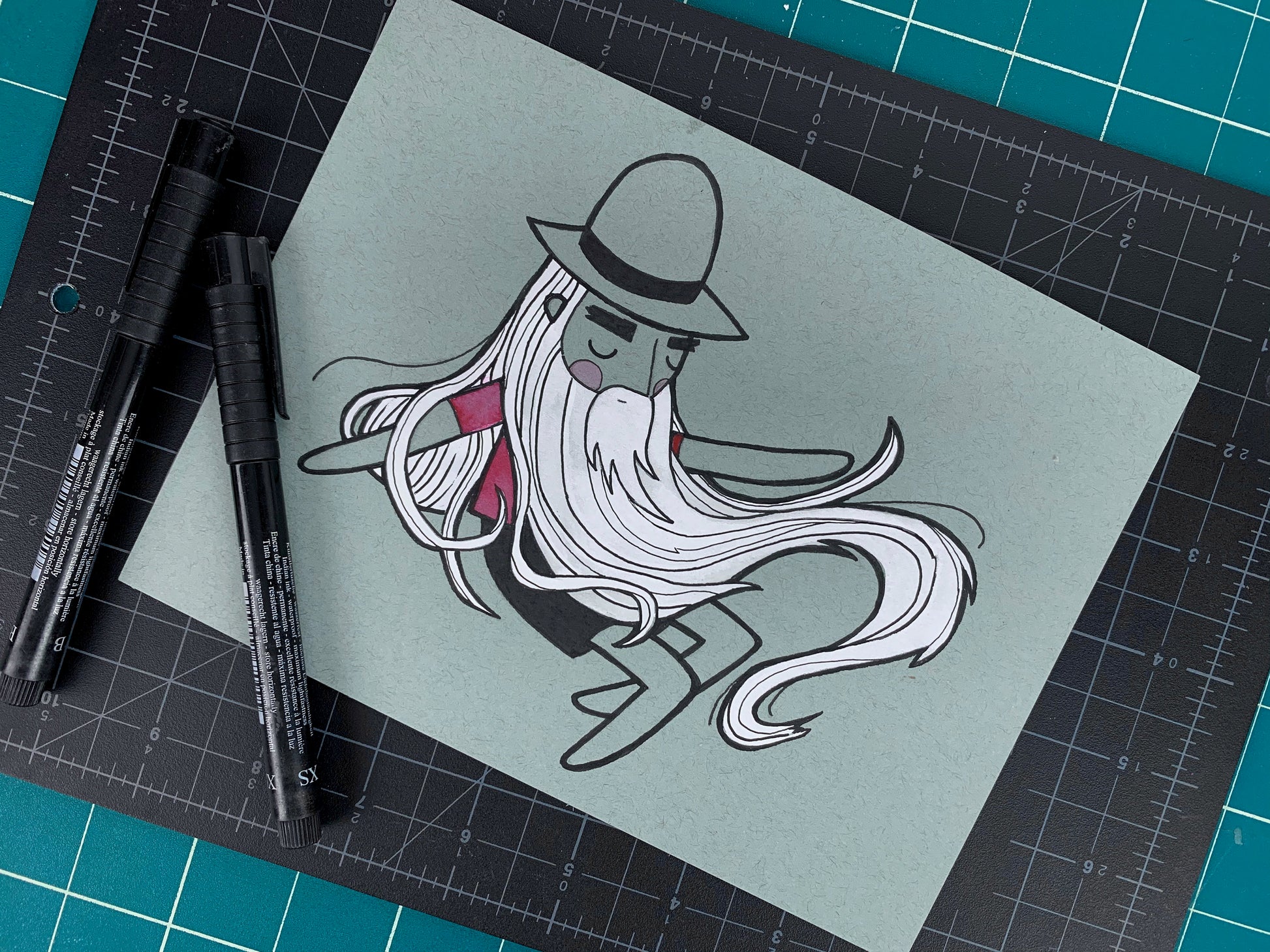 Studio shot of an original illustration of a sleeping Rip Van Winkle like man with a long white beard. Made using ink, watercolor, and gouache.