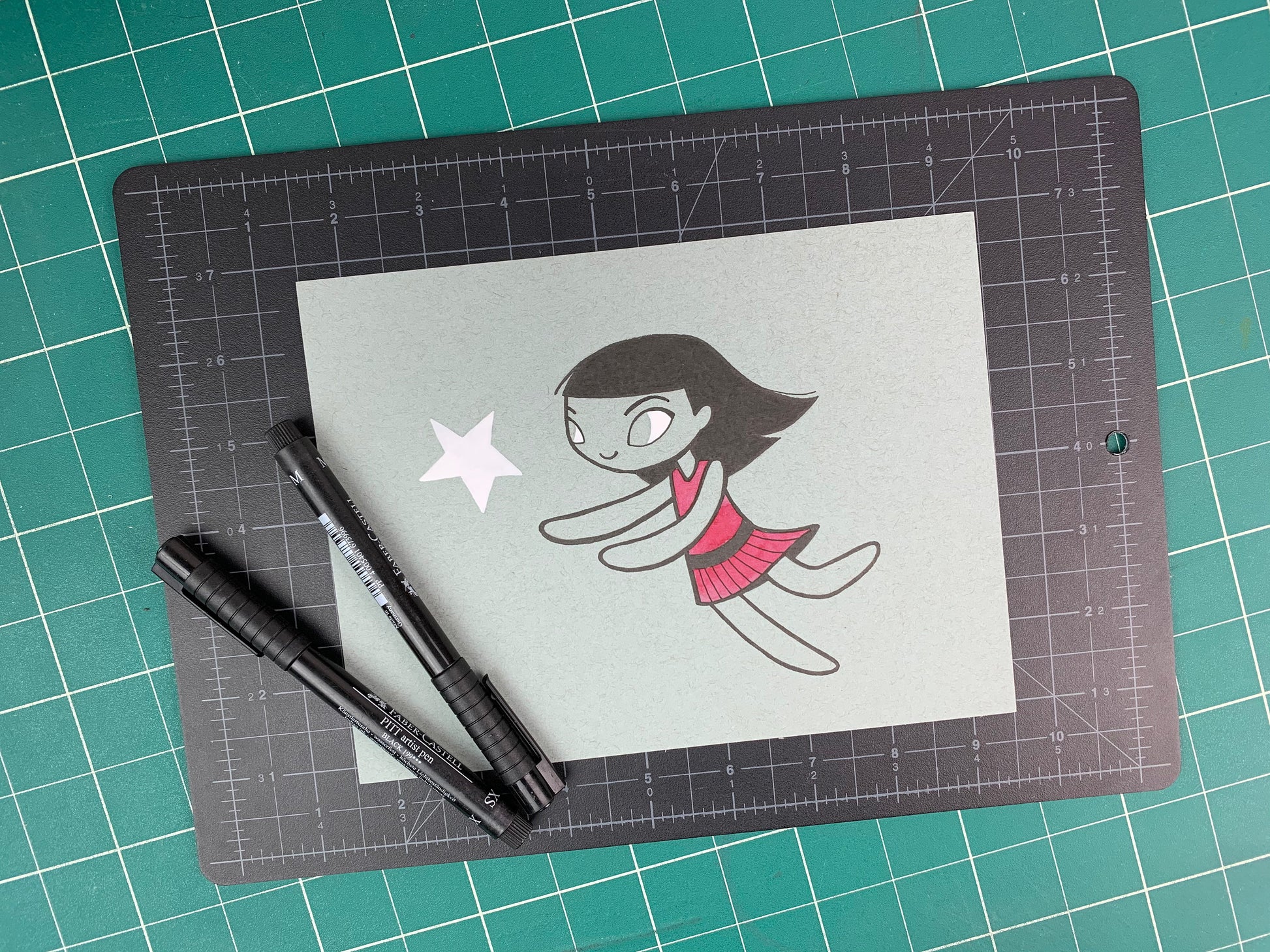 Studio shot of an original illustration of a girl in a red dress chasing a white star. Made using ink, watercolor, and gouache.