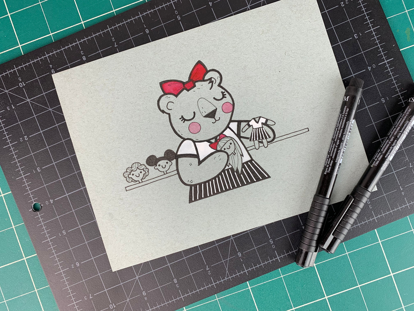 Studio shot of an original illustration of a teddy bear girl building a human doll for herself. Made using ink, watercolor, and gouache.