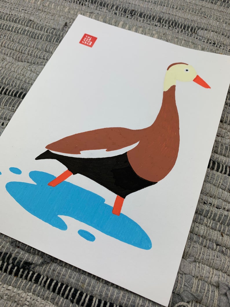 Original artwork of a brown duck with a cream colored head, orange beak, and orange legs wades through the shallow water.