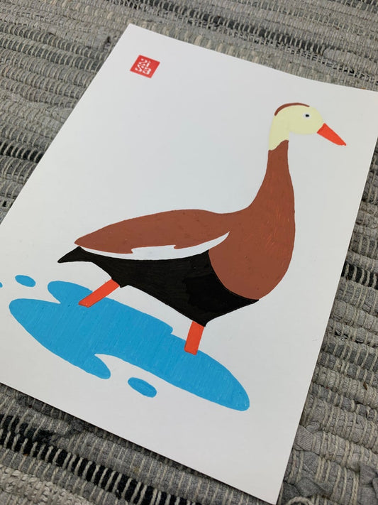 Original artwork of a brown duck with a cream colored head, orange beak, and orange legs wades through the shallow water.