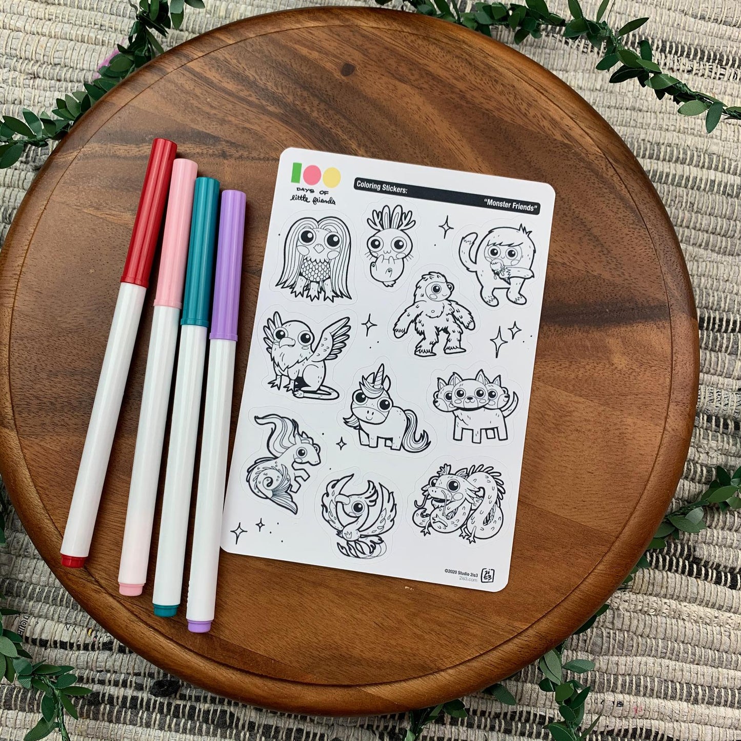 Markers and a sticker sheet with 10 little animal stickers on it. A Jackalope, Hellhound, Griffin, Phoenix, Hippocampus, Dragon, Unicorn, Bigfoot/Sasquatch, Yeti/Abominable Snowman, and Amabie.