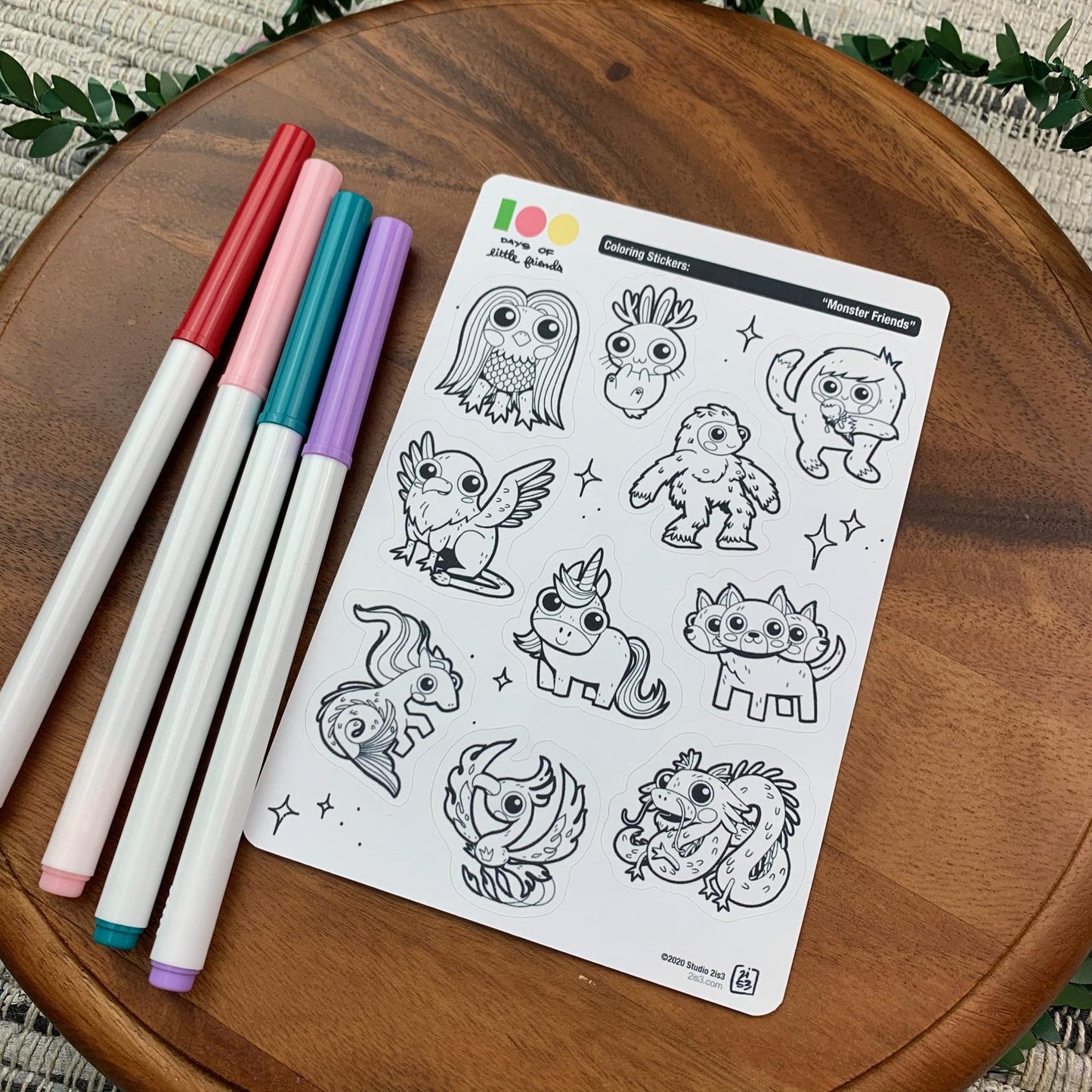 Markers and a sticker sheet with 10 little animal stickers on it. A Jackalope, Hellhound, Griffin, Phoenix, Hippocampus, Dragon, Unicorn, Bigfoot/Sasquatch, Yeti/Abominable Snowman, and Amabie.