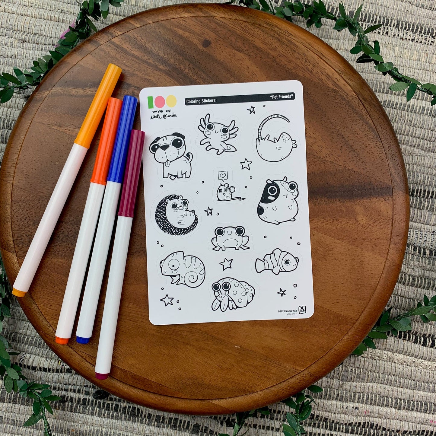 Markers and a sticker sheet with 10 little animal stickers on it. A Pug, Salamander, Rat, Mouse, Hedgehog, Guinea Pig, Frog, Chameleon, Hermit Crab, and Clown Fish.