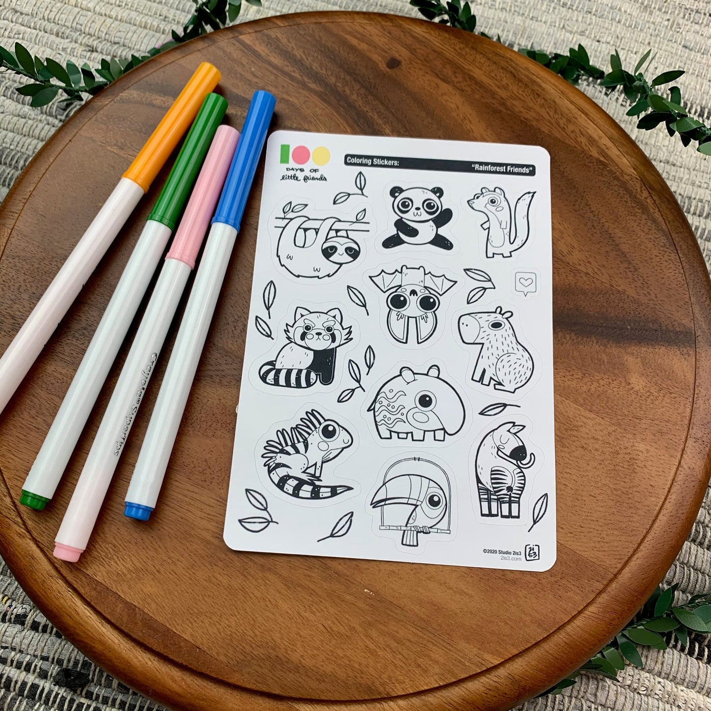 Markers and a sticker sheet with 10 little animal stickers on it. A Panda, Sloth, Mongoose, Bat, Red Panda, Capybara, Tapir, Iguana, Toucan, and Okapi.
