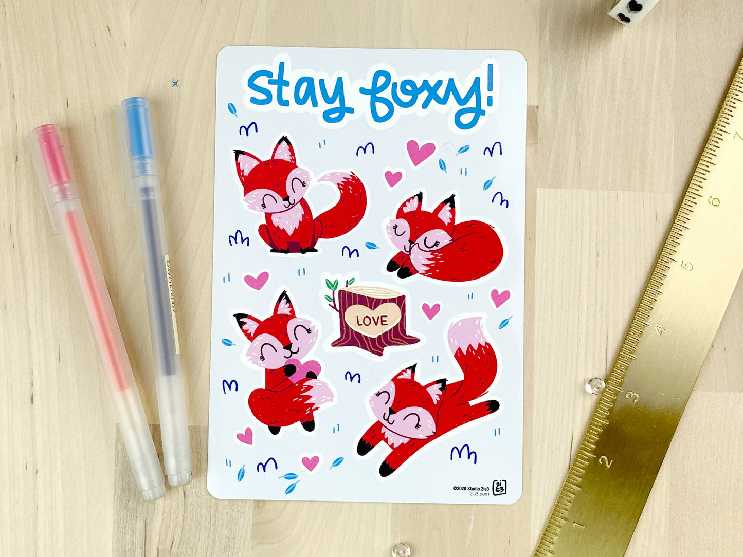 A sticker sheet with four cute little foxes, a tree stump with "love" carved into it, and some small heart stickers.