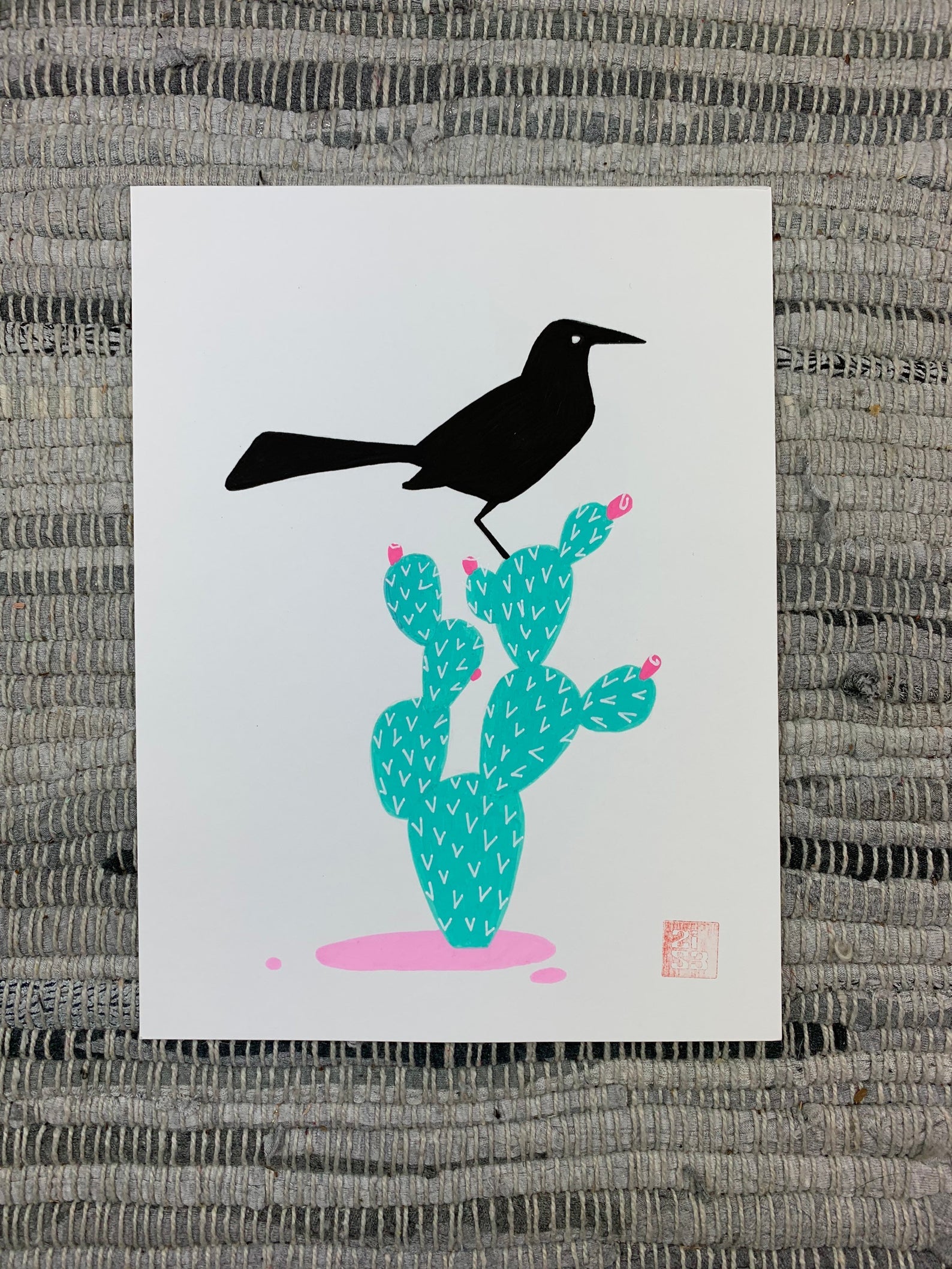 Original artwork of a black bird, boat-tailed grackle, standing on a prickly pear cactus.