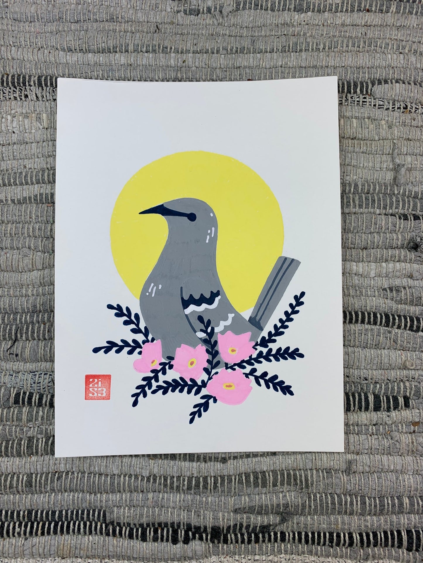 Original artwork of the Texas state bird, the northern mocking bird, in front of a geometric circle shape with a cluster of pink evening primrose (Oenothera speciosa), an abundant Texas wildflower.