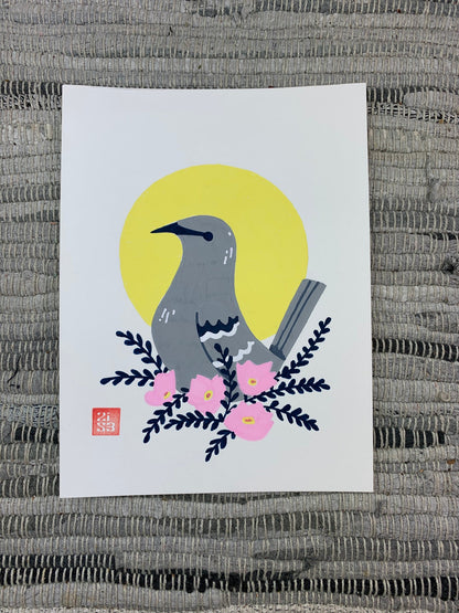 Original artwork of the Texas state bird, the northern mocking bird, in front of a geometric circle shape with a cluster of pink evening primrose (Oenothera speciosa), an abundant Texas wildflower.