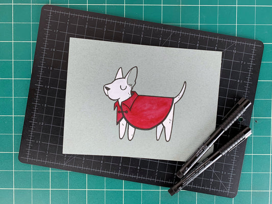 Studio shot of an original illustration of a white puppy dog wearing a smart red coat or jacket. Made using ink, watercolor, and gouache.
