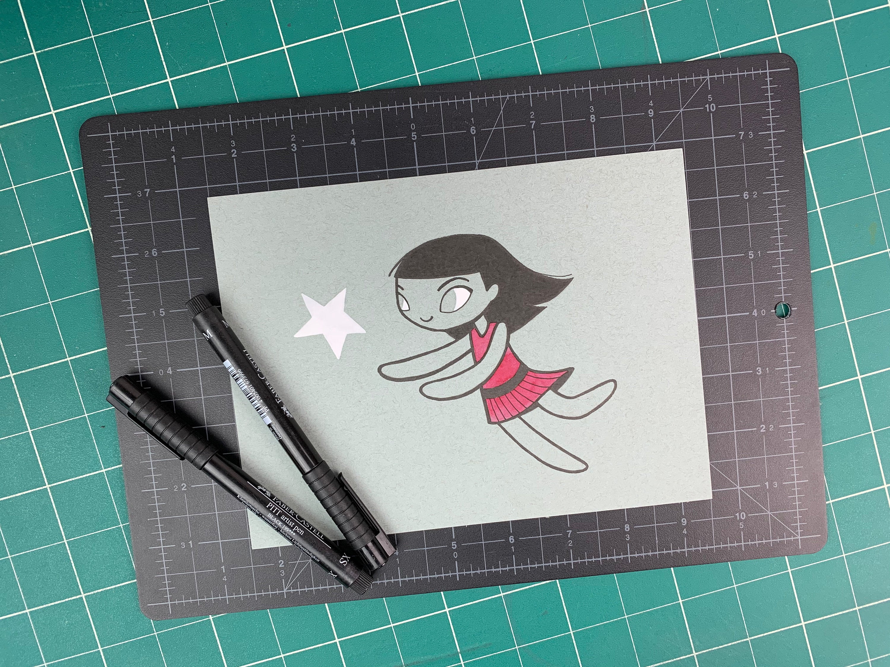 Studio shot of an original illustration of a girl in a red dress chasing a white star. Made using ink, watercolor, and gouache.