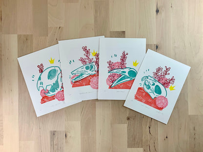 Original art prints by Amber Orenstein. Four relief prints of animal skulls with floral accents - crow, big cat lion, rat, and barracuda skulls.