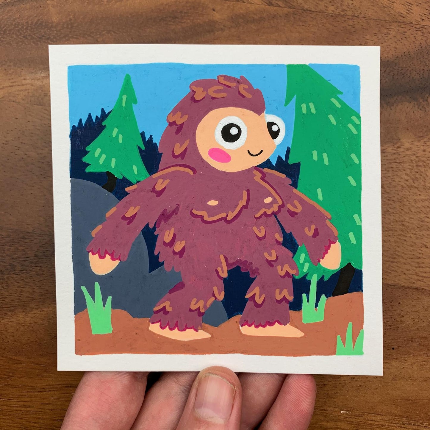 Original artwork of a cute bigfoot (or sasquatch) in a foresty Pacific Northwest scene. Materials used: Uni-Posca paint markers.