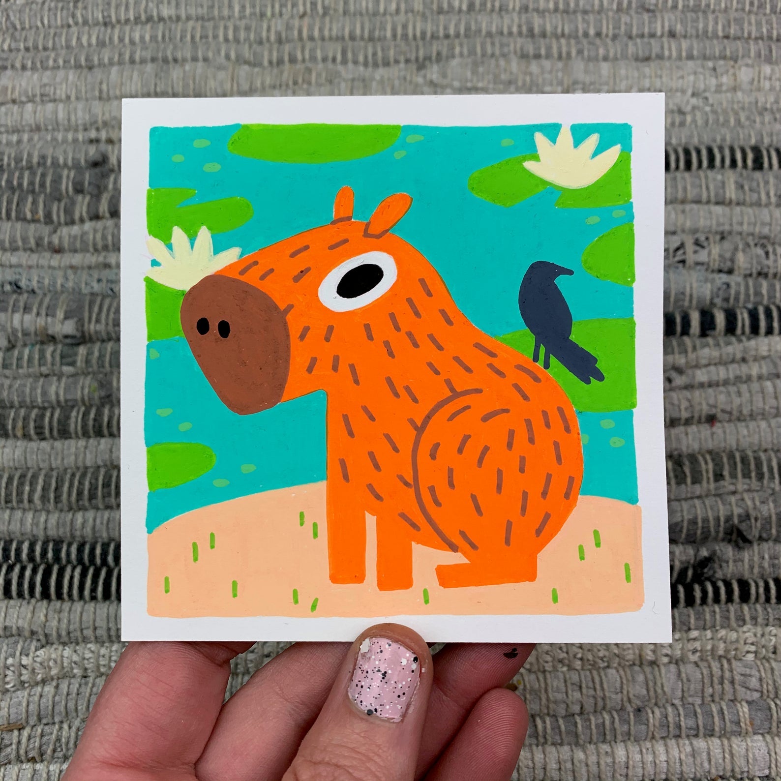 Original artwork of a cute orange capybara with a bird pal sitting on his shoulder. Materials used: Uni-Posca paint markers.