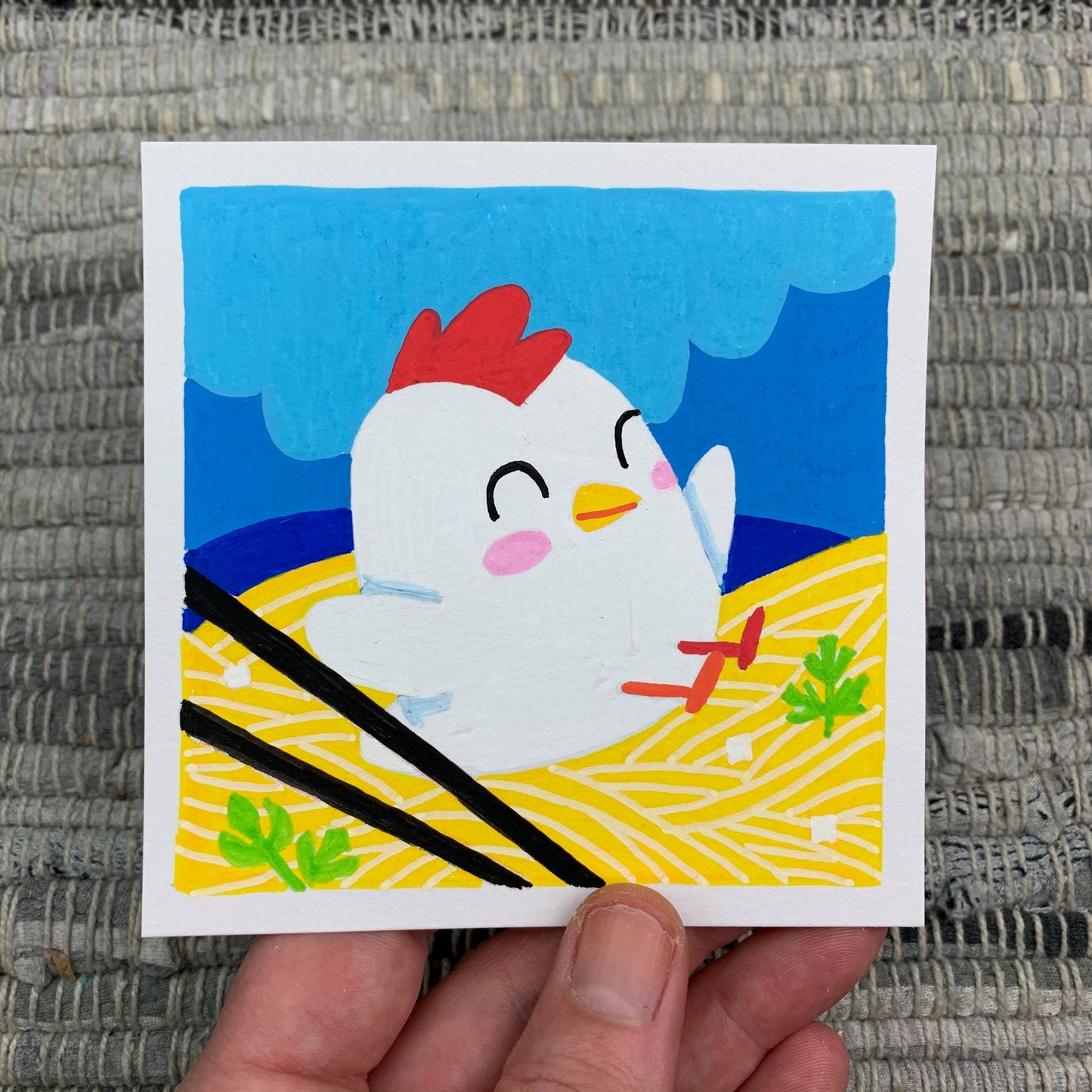Original artwork of a cute chicken sitting in a bowl of noodles with some chop sticks on the side. Materials used: Uni-Posca paint markers.