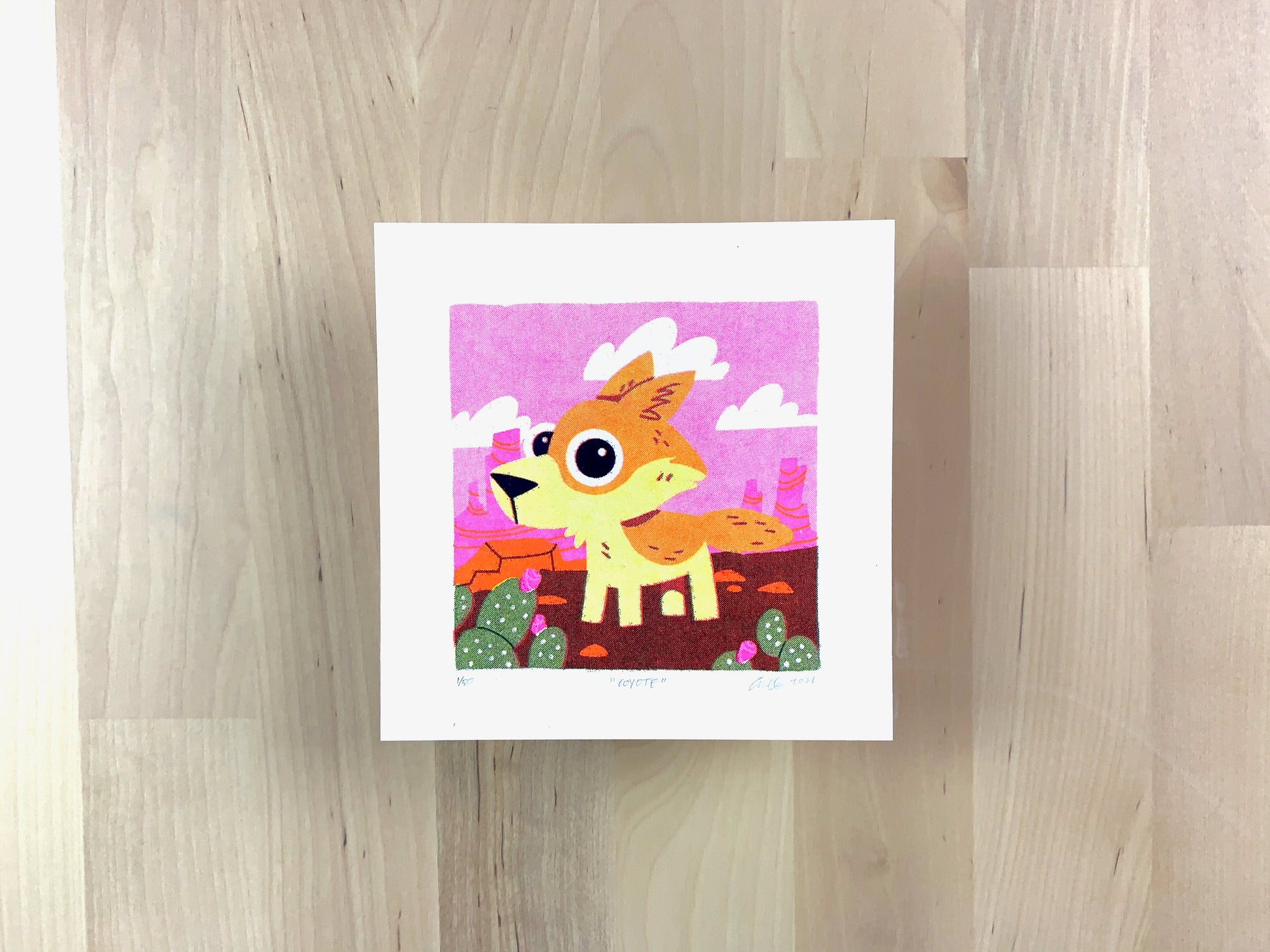 Risograph print of a cute coyote illustration in a pink desert scene.