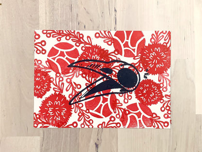 Original art print by Amber Orenstein. Block printed crow skull over red floral background pattern.