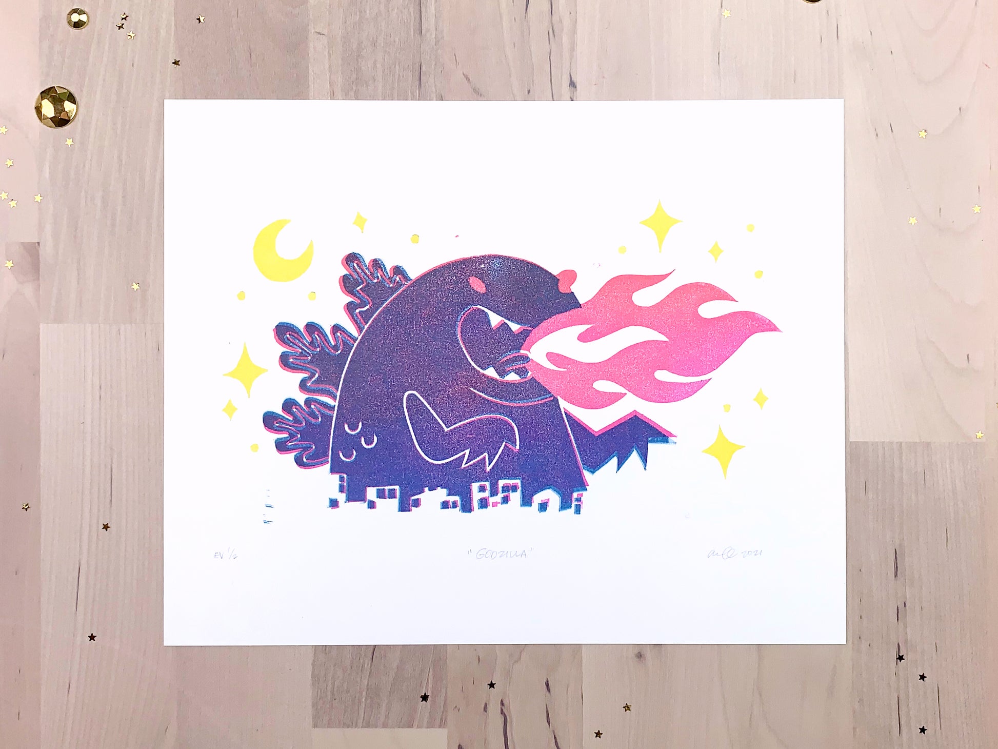 Original limited edition #1 art print by Amber Orenstein. Two color, pink and turquoise, reduction block print of a Japanese kaiju monster roaring with flames while destroying a city with yellow stars and moon.