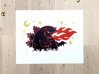 Original limited edition #5 art print by Amber Orenstein. Two color, red and black, reduction block print of a Japanese kaiju monster roaring with flames while destroying a city with gold stars and moon.