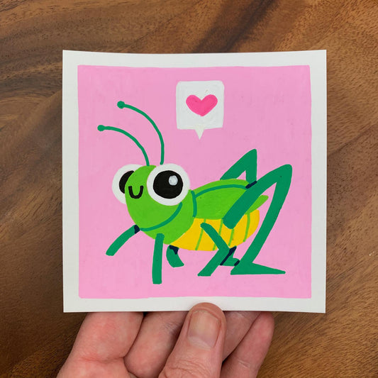 Original artwork of a cute grasshopper with a speech bubble above it with a heart in it on a pink background. Materials used: Uni-Posca paint markers.