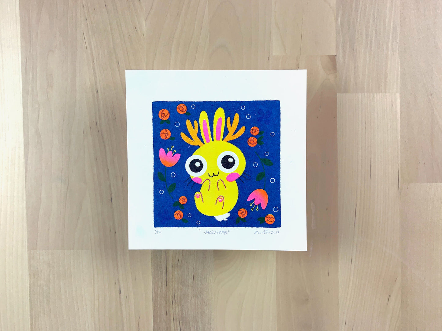 Risograph print of a cute yellow jackalope bunny illustration on blue background and flowers.