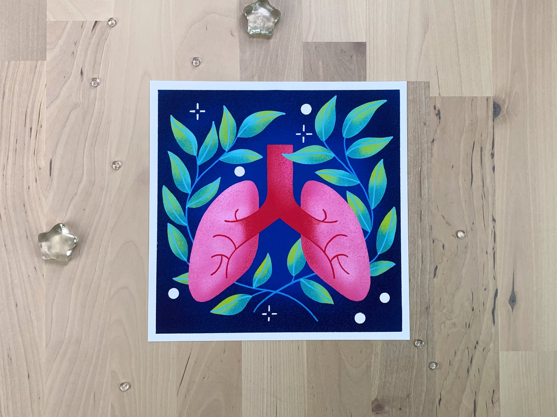 An illustration of a pair of lungs in front of some green leaves.