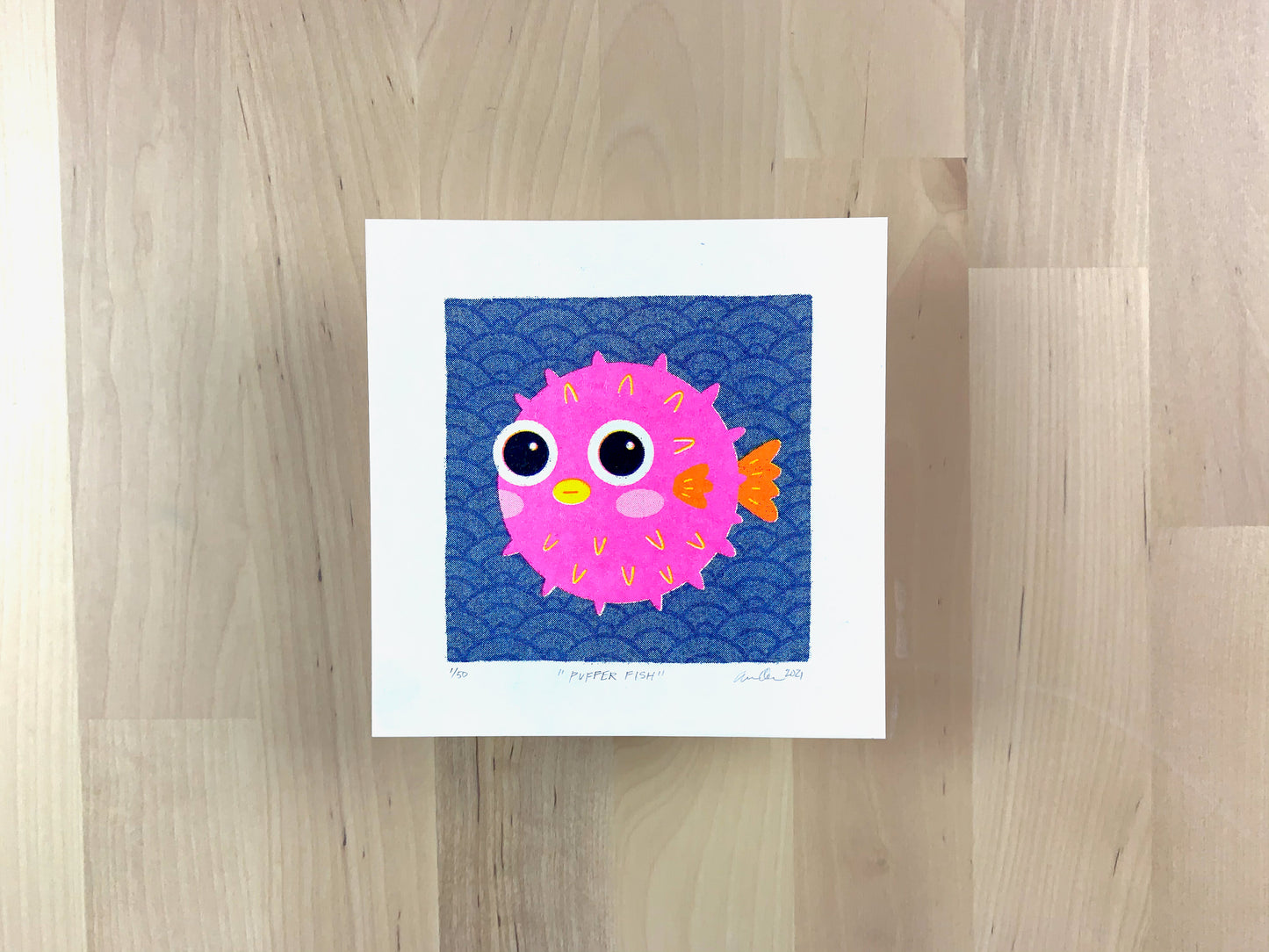 Risograph print of a cute pink pufferfish illustration on a wave pattern background.