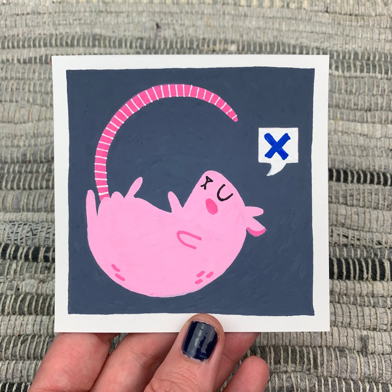 Original artwork of a pink rat with closed eyes and a speech bubble with an "x" in it. Materials used: Uni-Posca paint markers.