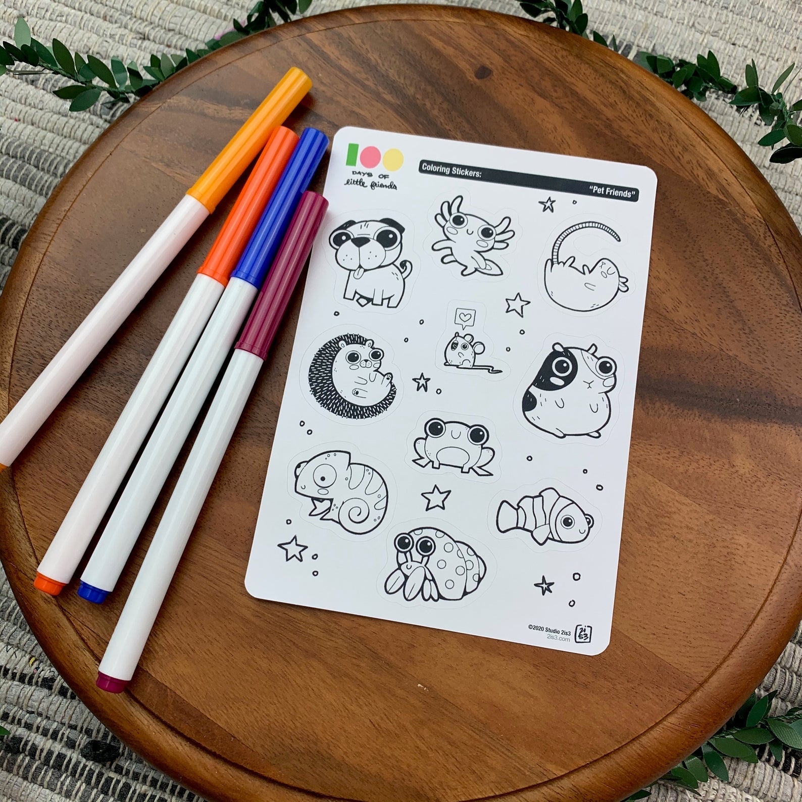 Markers and a sticker sheet with 10 little animal stickers on it. A Pug, Salamander, Rat, Mouse, Hedgehog, Guinea Pig, Frog, Chameleon, Hermit Crab, and Clown Fish.