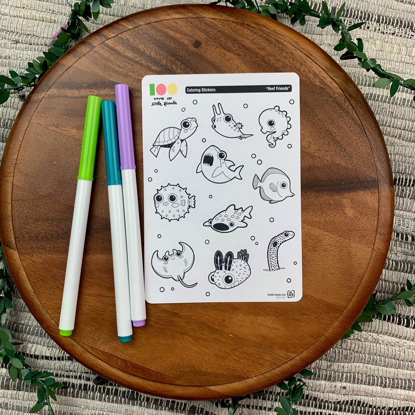 Markers and a sticker sheet with 10 little animal stickers on it. A Sea Turtle, Cowfish, Seahorse, Shark, Pufferfish, Whale Shark, Tang, Ray, Nudibranch, and Garden Eel.