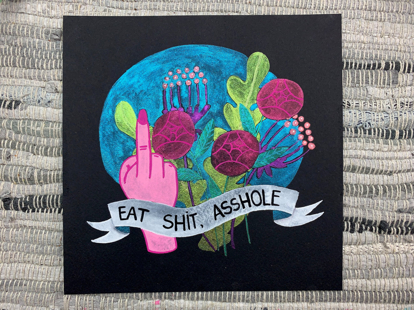 A painting of a hand "flipping the bird" with a bouquet of color shifting flowers behind it and a banner that says "Eat shit, asshole" in front.
