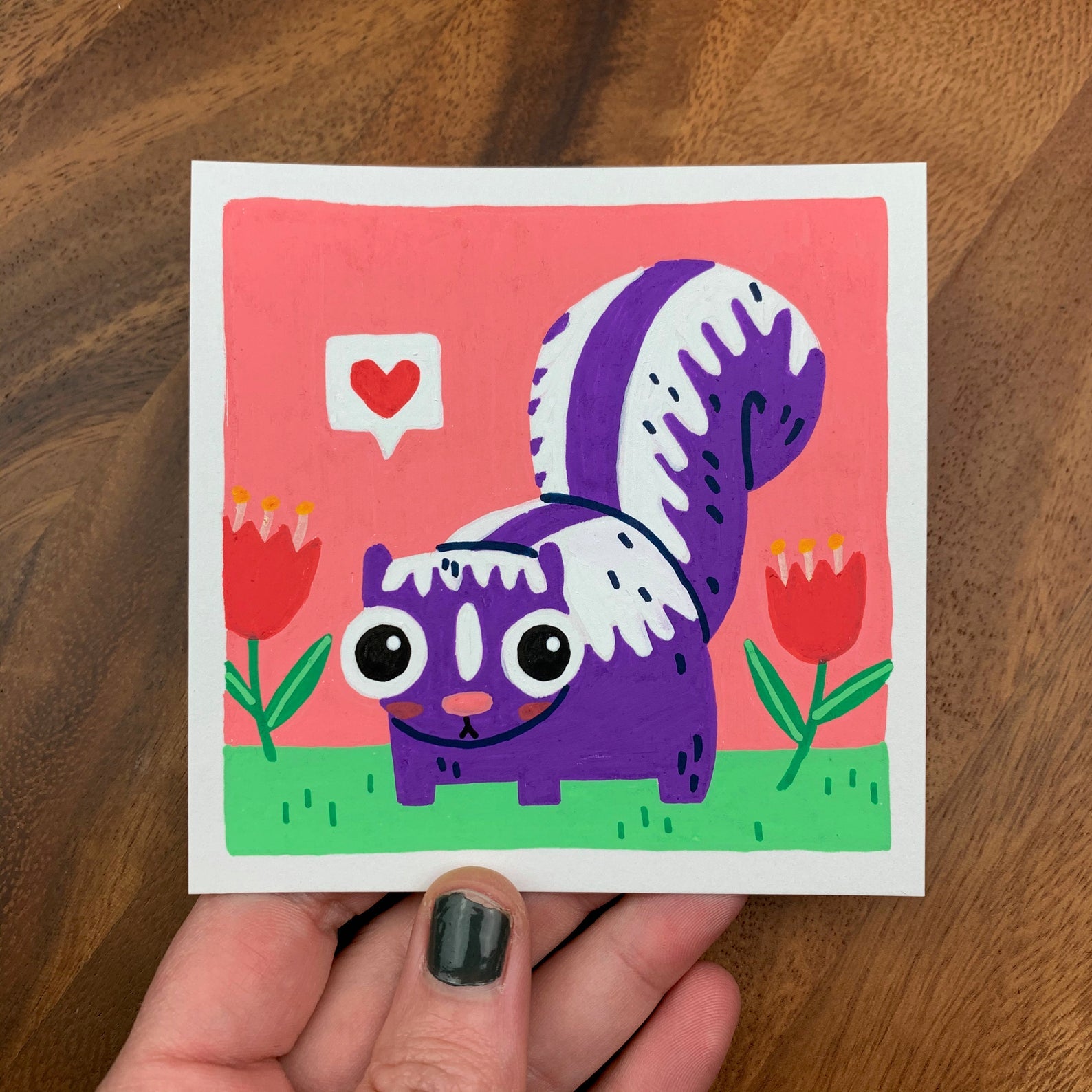 Original artwork of a cute purple skunk in a tulip field with a heart inside a speech bubble. Materials used: Uni-Posca paint markers.