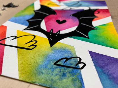 Original artwork depicting a colorful geometric watercolor and gouache painting of a bat.